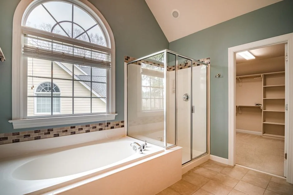 Anonymous person in yellow rubber gloves using simple sponge for cleaning mirror in bathroom