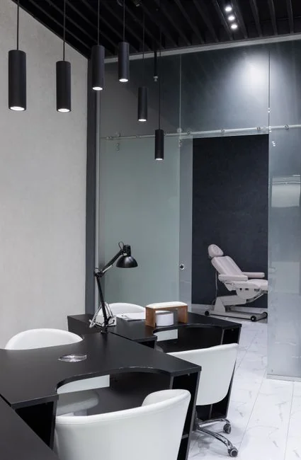 Pièce minimaliste avec une personne nettoyant une chaise à l’aide d’une éponge et d’un produit de nettoyage.